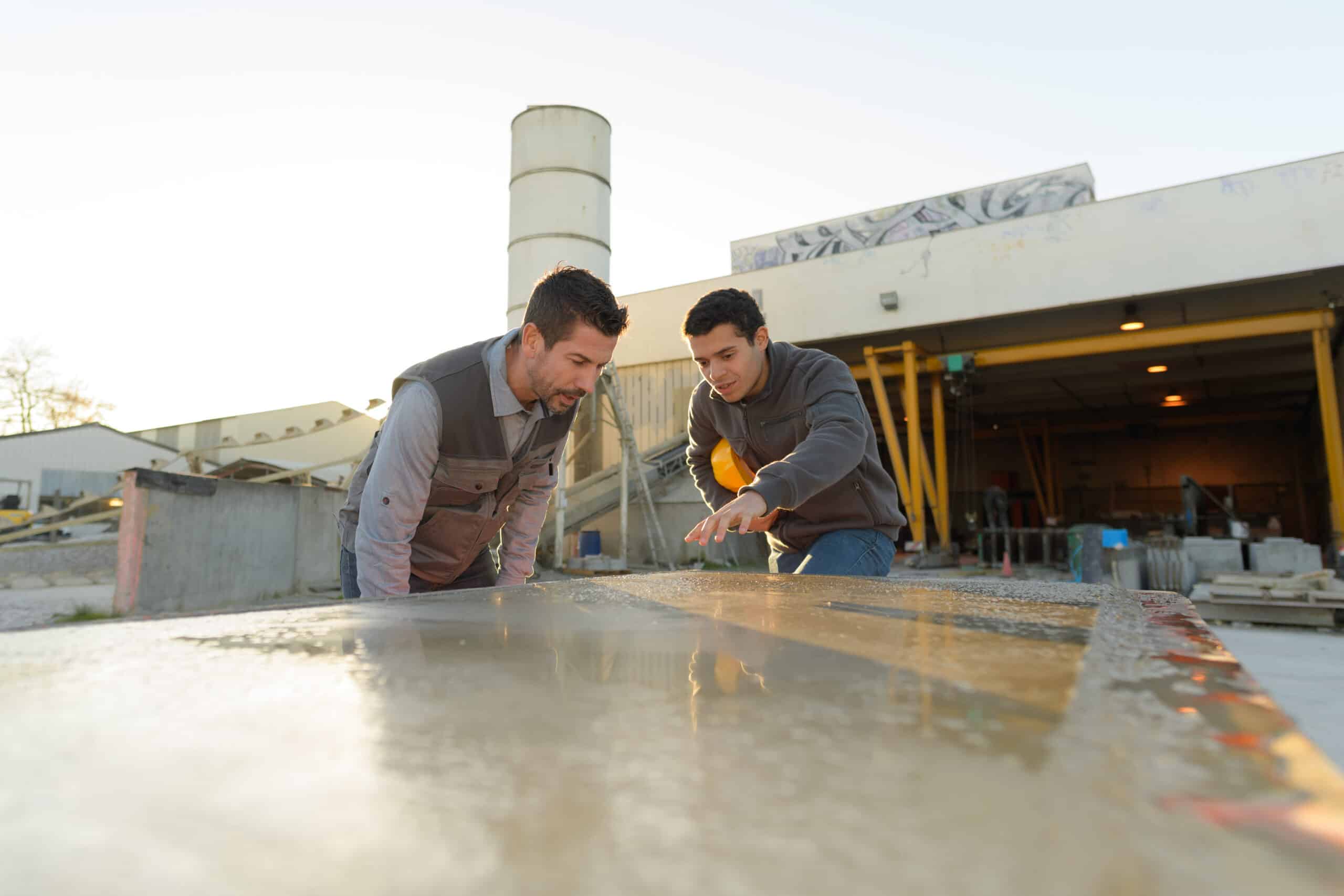 twee steenverwerkers controleren slab buiten fabriek